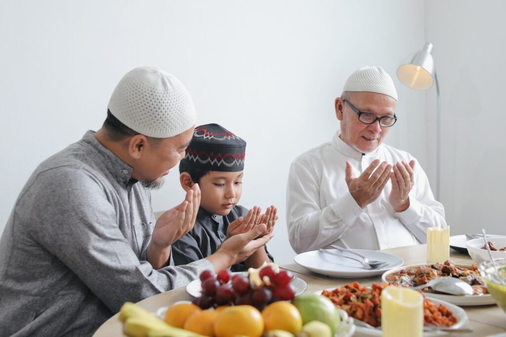 Father Teaching Son To Praying Dua Before Eating Special Dish On Eid Al Fitri Moment