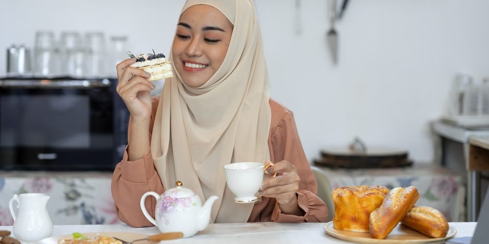 young muslim woman in hijab eating sweets, bread, waffles, cakes, healthy food menu and happily drin young muslim woman in hijab eating sweets, bread, waffles, cakes, healthy food menu and happily drin